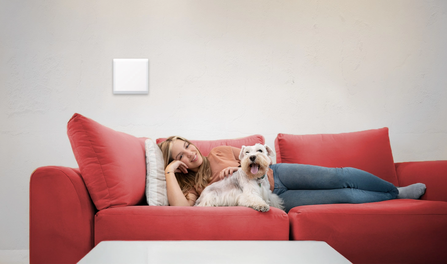 Frau liegt mit Hund auf Couch