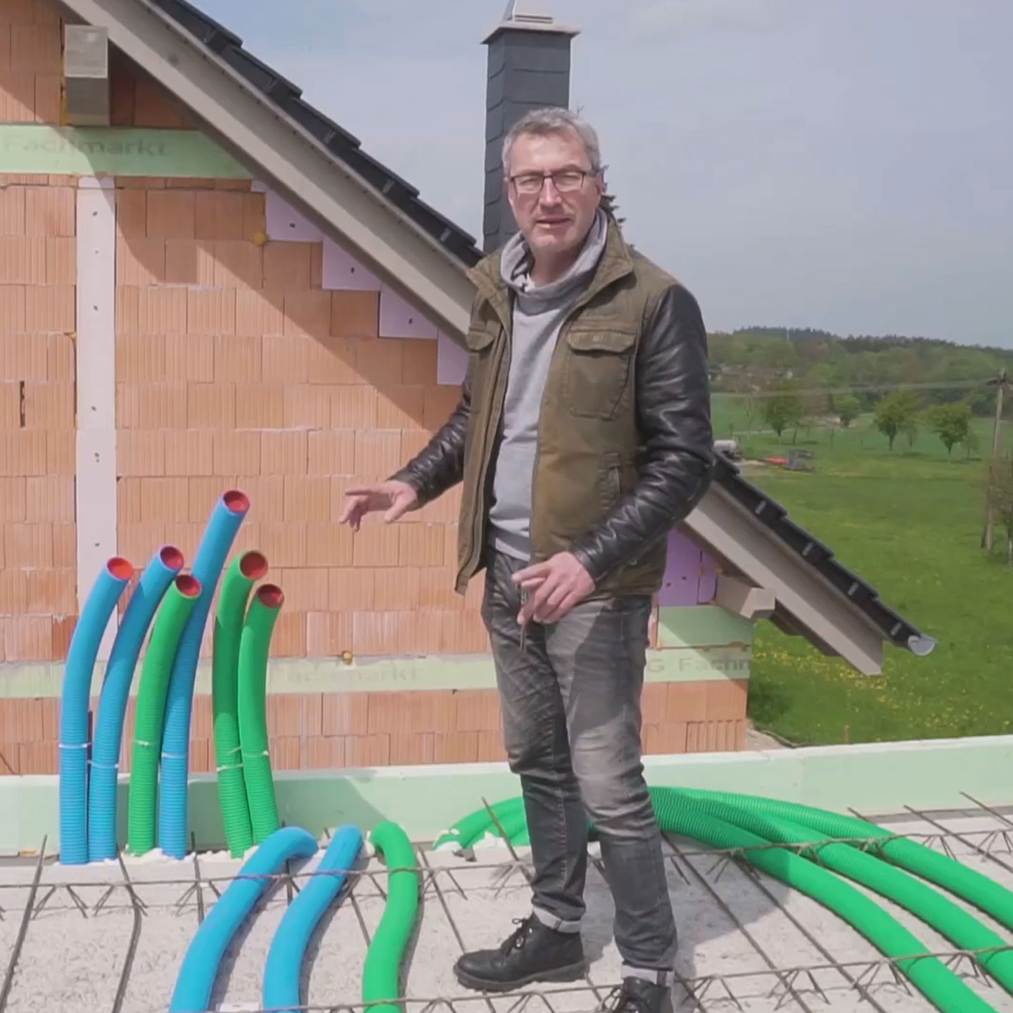 Mann auf Dach mit Lüftungsrohren