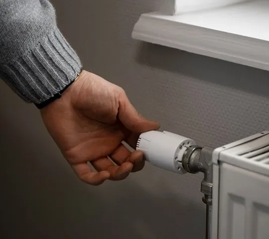 Hand schaltet Heizung aus