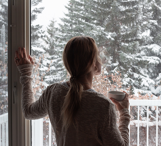 Frau vor winterlichem Fenster