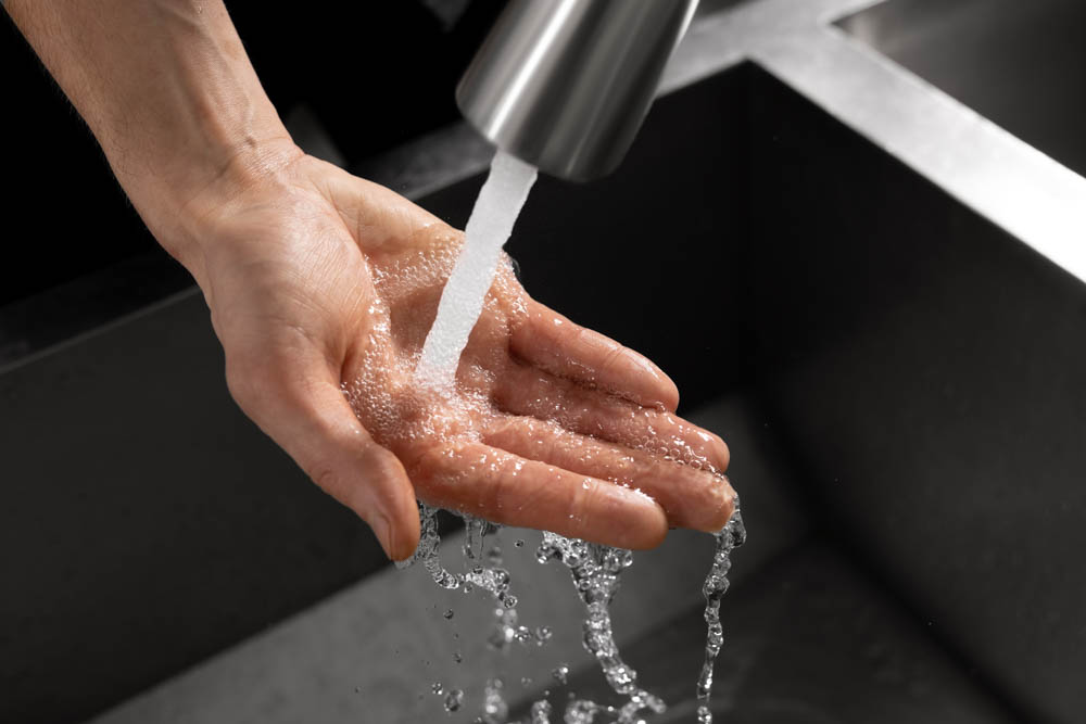 Hand unter Wasserhahn