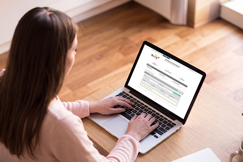 Teilweise mit KI bearbeitet: Eine Frau sitz an einem Laptop und hat die Seite des Selfio Fußbodenheizungs-Konfigurators geöffnet