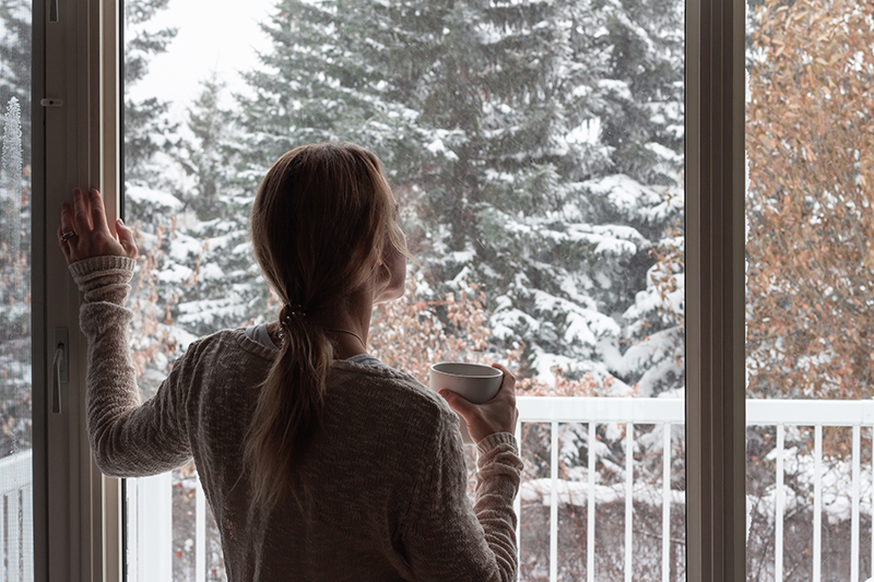 Frau vor winterlichem Fenster