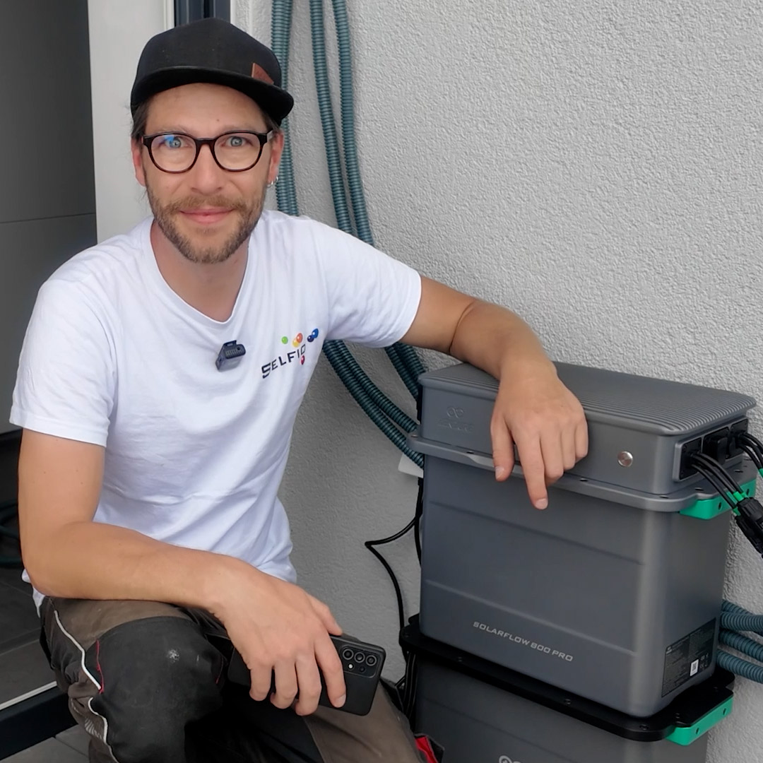 Mann hockt neben Zendure Speicher