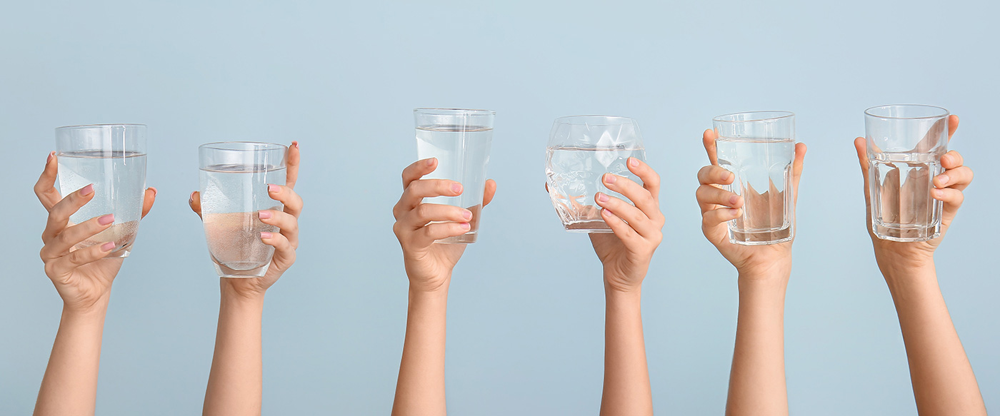 6 Hände mit Wasser gefüllte Gläser
