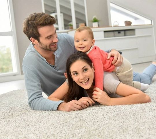 Familie liegt auf Teppich