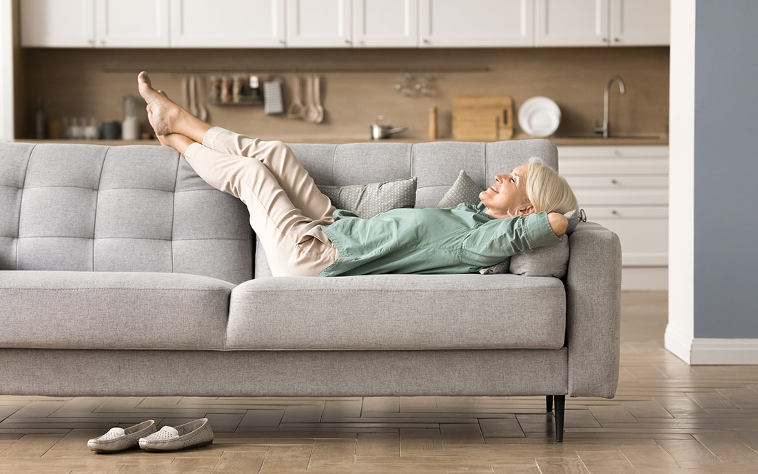 Ältere Frau entspannt auf Sofa
